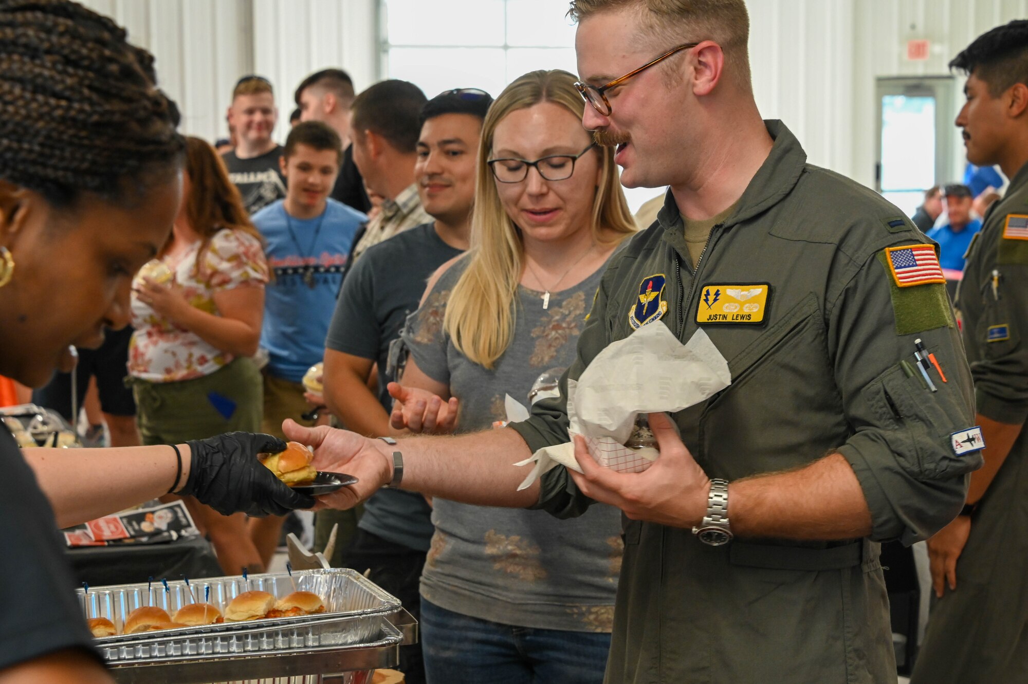 U.S. Air Force 1st Lt. Justin Lewis, 97th Training Squadron student pilot, accepts food from community members at the “Taste of Altus” event, July 11, 2022. There were more than 15 vendors at the event handing out free food samples. (U.S. Air Force photo by Senior Airman Kayla Christenson)