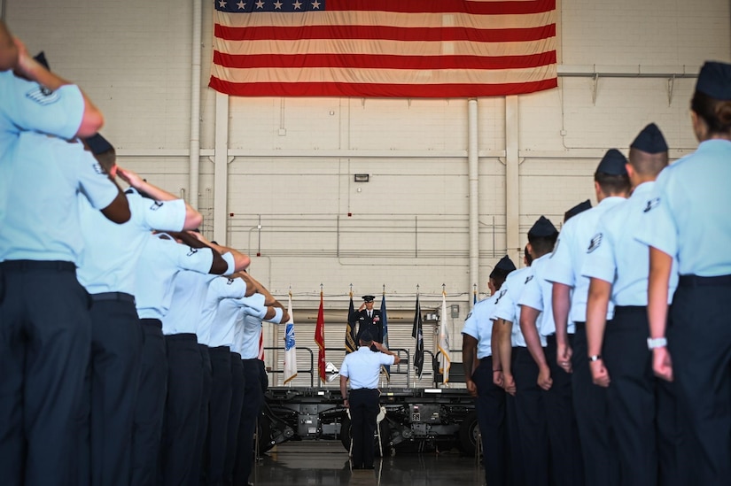 Three military members stand at attention