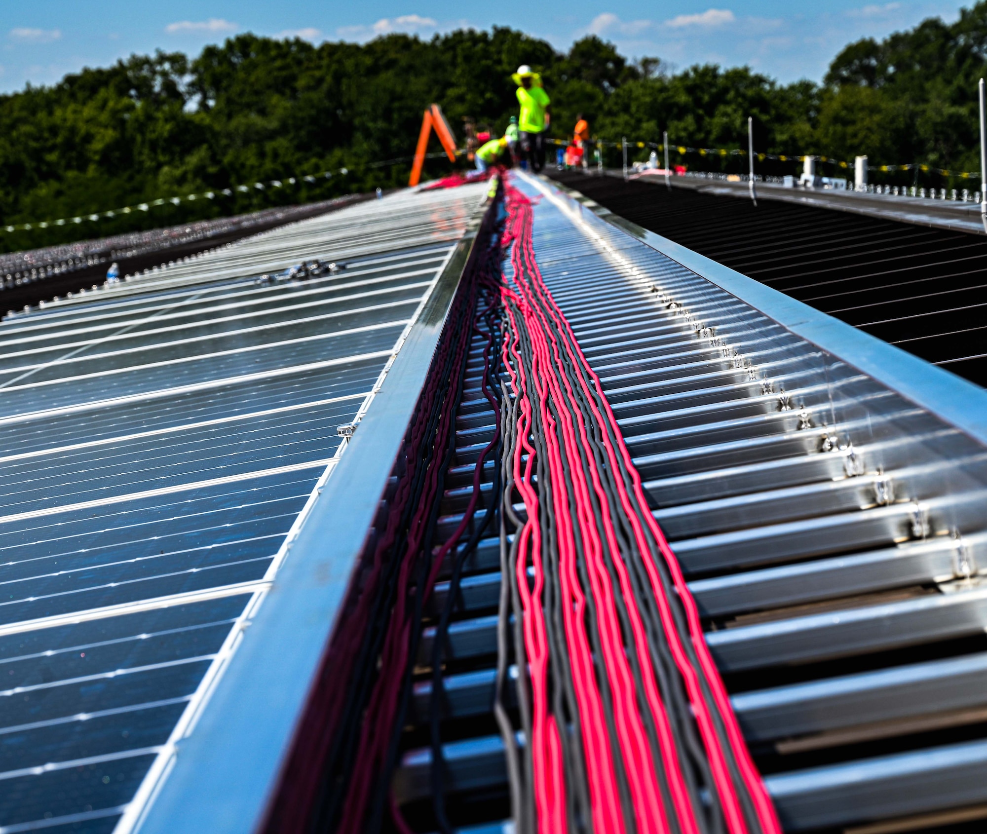 More than 7,100 photovoltaic solar panels are being laid down on rooftops across the joint base in an project to reduce the demand off the commercial electric grid and make the base's utilities more resilient.