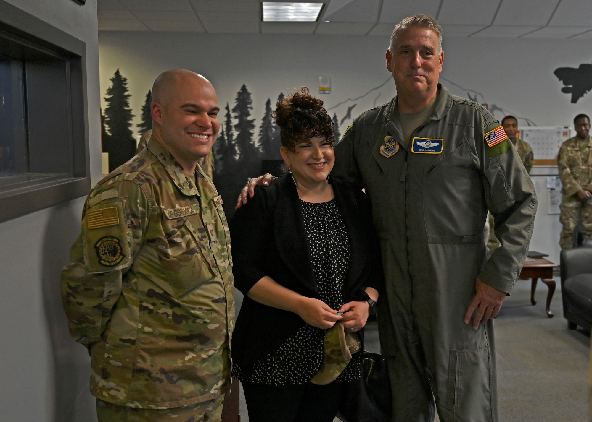 U.S. Air Force Gen. Mike Minihan, right, Air Mobility Command commander, poses for a photo with Tech. Sgt. Arturo De Gongora, left, airman dorm leader with the 627th Civil Engineer Squadron, and his wife at Joint Base Lewis-McChord, Washington, July 7, 2022. Minihan coined De Gongora as a star performer during his visit to JBLM. (U.S. Air Force photo by Senior Airman Callie Norton)