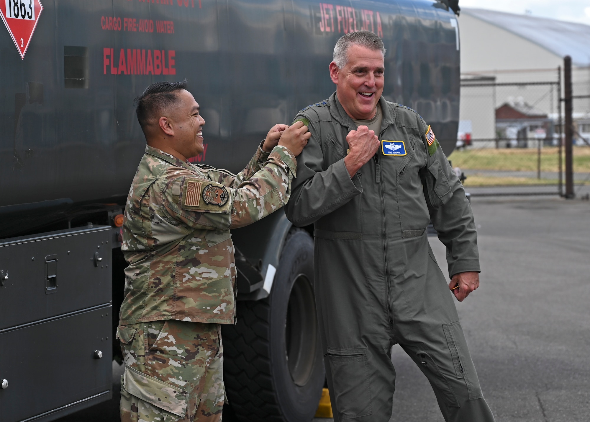 U.S. Air Force Tech. Sgt. Jeffrey Panen, left, fuels service center NCO in charge with the 627th Logistics Readiness Squadron, places a patch on Gen. Mike Minihan, Air Mobility Command commander, during his visit to Joint Base Lewis-McChord, Washington, July 7, 2022. Minihan and Chief Master Sgt. Brian Kruzelnick, AMC command chief, spent two days visiting Team McChord to experience the way America’s Airlift Wing executes rapid global mobility. (U.S. Air Force photo by Senior Airman Callie Norton)