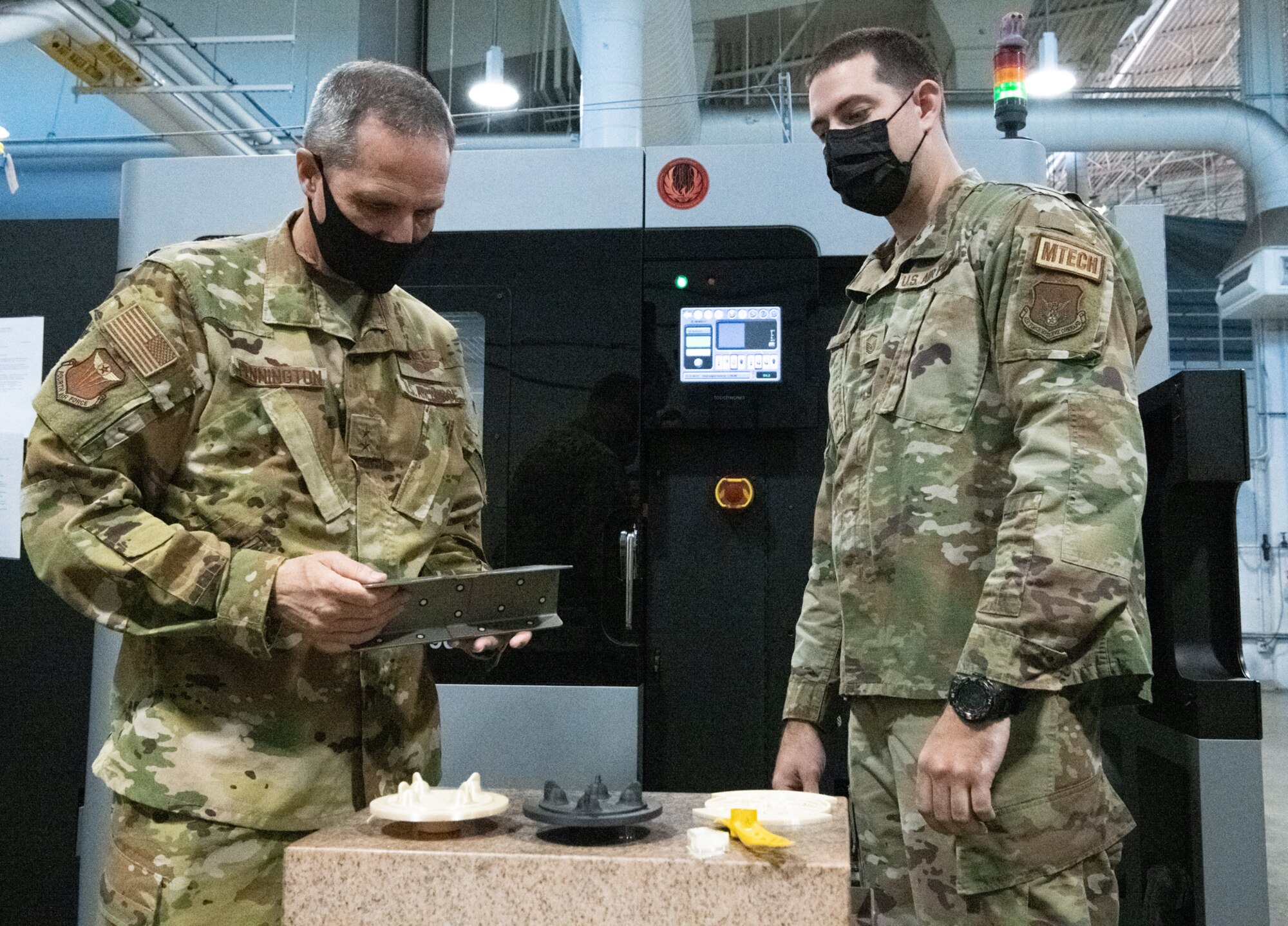 Master Sgt. Reed, 349th Maintenance Squadron, demonstrates the benefits of 3D printing at Travis Air Force Base, Calif. to Maj. Gen. Jeffrey T. Pennington, 4th Air Force commander, on July 10, 2022. The opportunity was one of many that allowed the 349th Air Mobility Wing to showcase its people, mission, accomplishments and innovative efforts