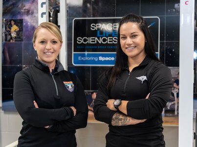 U.S. Air Force Staff Sgt. Emily Valdovinos (right), Special Warfare Human Performance Squadron physical medicine technician, poses for a portrait with Maj. Danielle Anderson (left), musculoskeletal medicine and rehabilitation lead, Astronaut Strength, Conditioning and Rehab Group, at the Johnson Space Center in Houston, Texas, Jun. 16, 2022. Valdovinos was hand-selected by the ASCR Group to help develop personalized strength, conditioning, and rehabilitative plans for NASA astronauts.