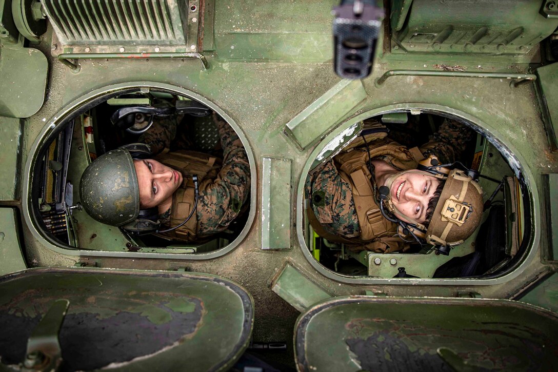 A look above at two Marines inside a military vehicle.