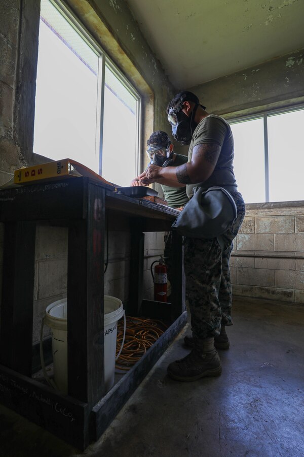 U.S. Marine Corps Cpl. Jean Marcos Perez, right, and Lance Cpl. Alex Lemus, both Chemical, Biological, Radioactive and Nuclear defense specialists with Combat Logistics Regiment 37, 3d Marine Logistics Group, prepare tear gas for annual Individual Protective Equipment Confidence Exercise qualification at Marine Corps Air Station Futenma, Okinawa, Japan, June 8, 2022. 3rd MLG, based out of Okinawa, Japan, is a forward deployed combat unit that serves as III MEF’s comprehensive logistics and combat service support backbone for operations throughout the Indo-Pacific area of responsibility. (U.S. Marine Corps photo by Lance Cpl. Sebastian Riveraaponte)