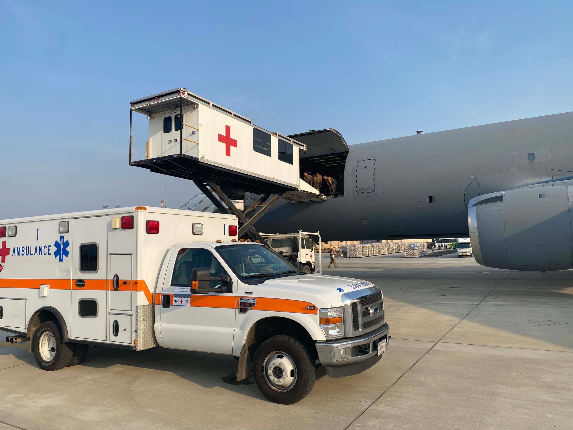 Medics and Airmen load equipment onto an aircraft.
