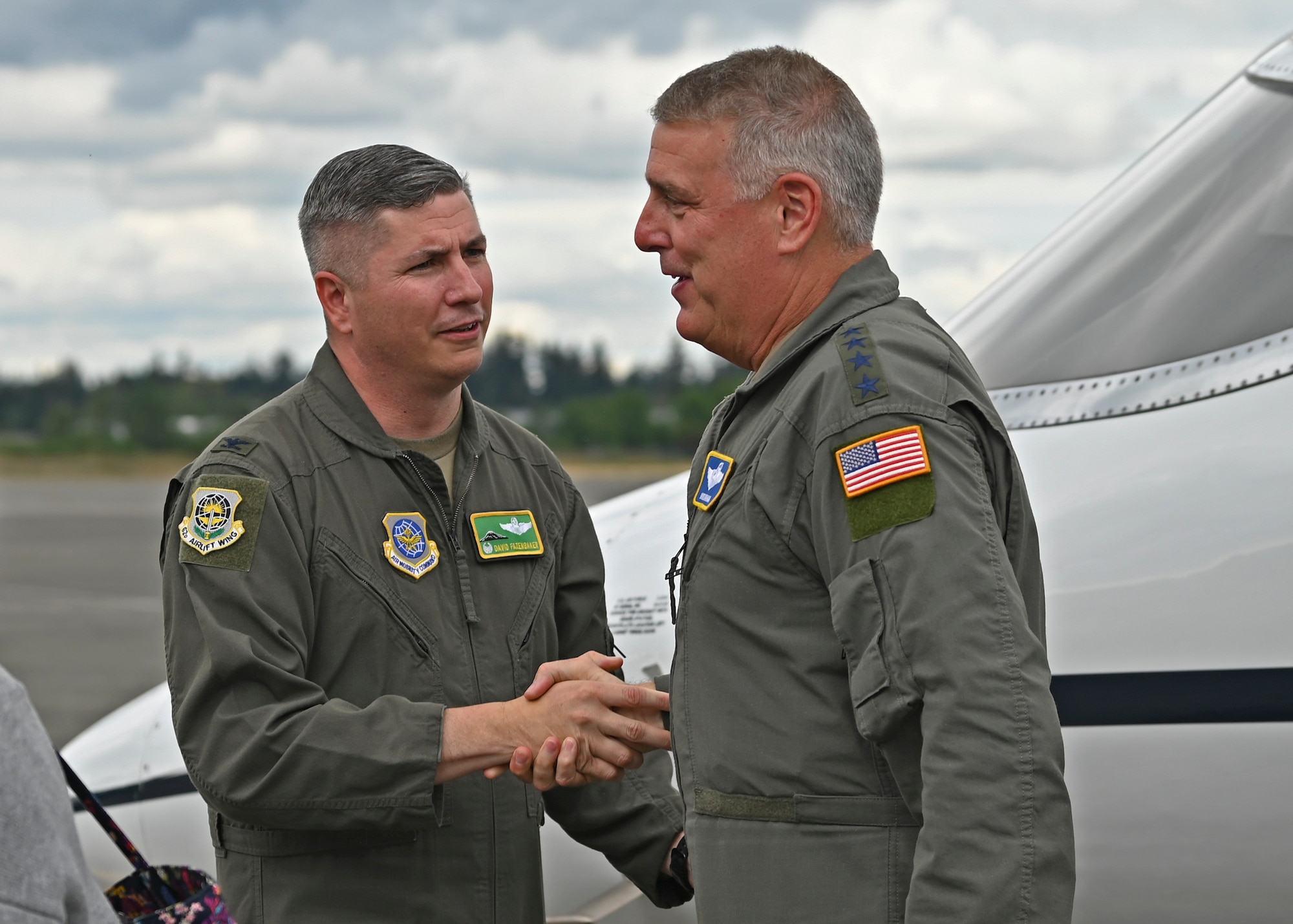 U.S. Air Force Col. David Fazenbaker, left, 62nd Airlift Wing commander, shakes hands with Gen. Mike Minihan, Air Mobility Command commander at Joint Base Lewis-McChord, Washington, July 6, 2022. Minihan and Chief Master Sgt. Brian Kruzelnick, AMC command chief, spent two days visiting Team McChord to experience the way America’s Airlift Wing executes rapid global mobility. (U.S. Air Force photo by Senior Airman Callie Norton)