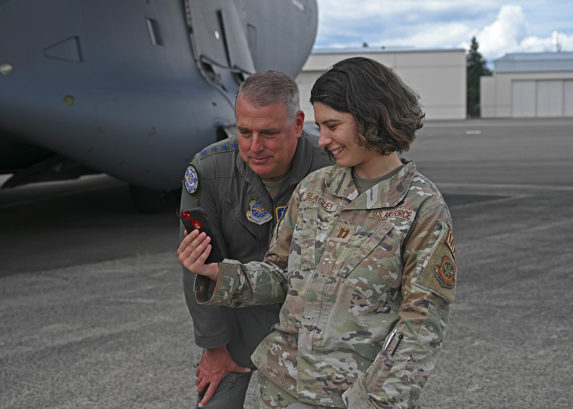 U.S. Air Force Gen. Mike Minihan, left, Air Mobility Command commander, and Capt. Madeline Slagley, 62nd Maintenance Squadron officer in charge, FaceTime Slagley’s family at Joint Base Lewis-McChord, Washington, July 7, 2022. Minihan coined Slagley as a star performer during his visit to JBLM. (U.S. Air Force photo by Senior Airman Callie Norton)