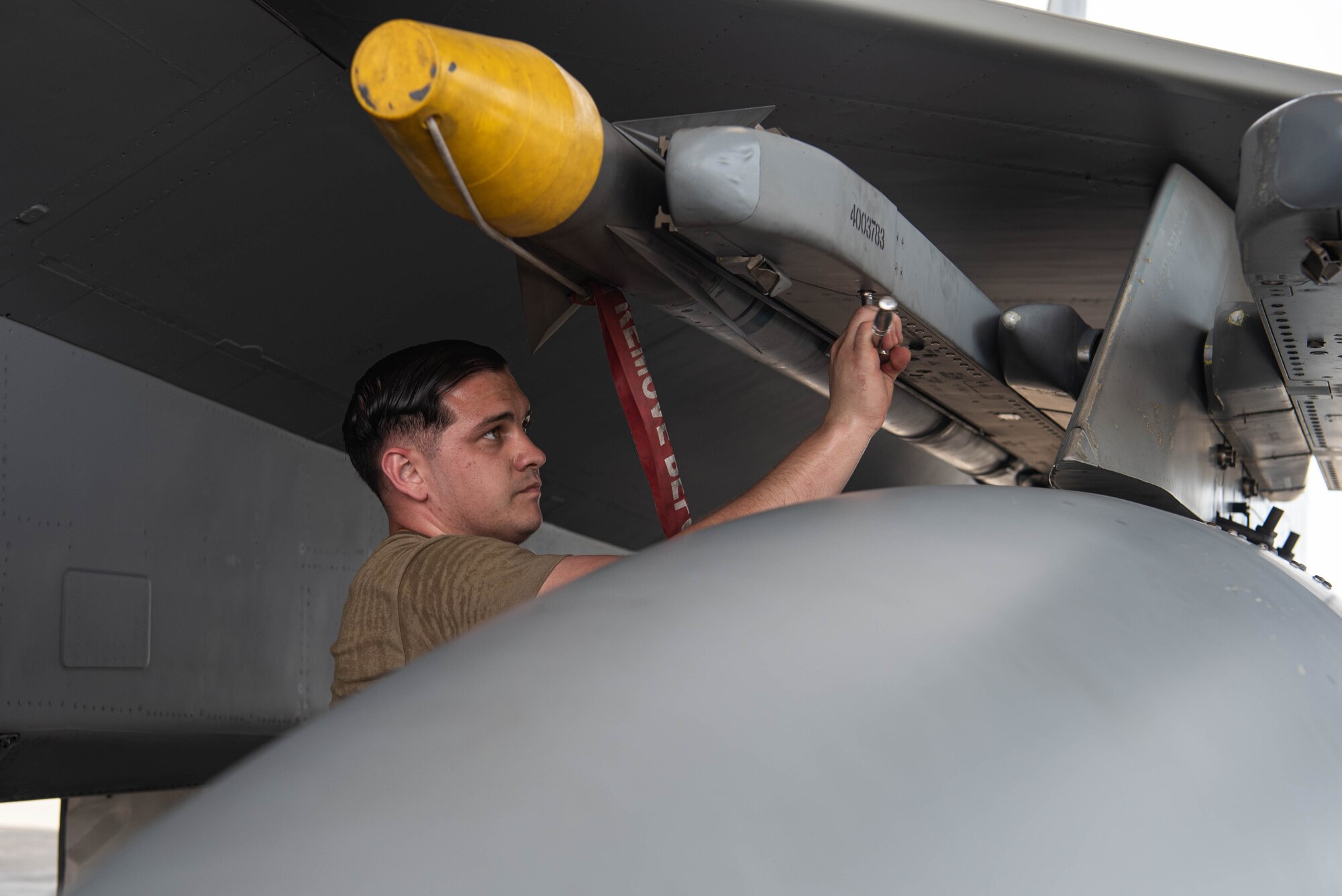 An Airman secures a missile on an F-15 during the Load Crew of the Quarter Competition at Kadena Air Base, Japan, July 15, 2022.