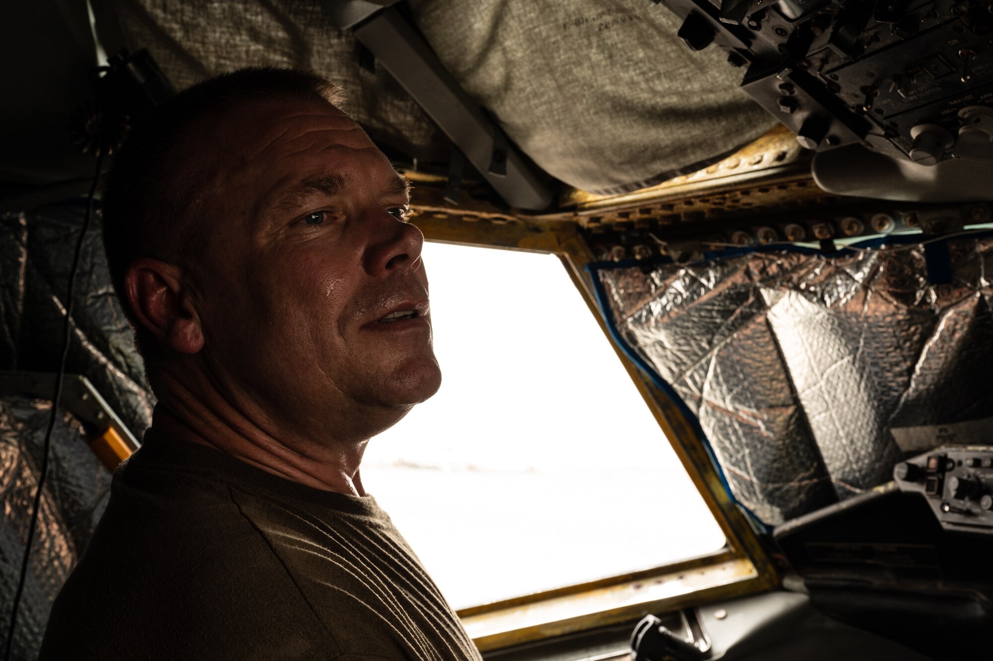 U.S. Air Force Col. Randy D. Schwinler, Commander 379th Expeditionary Maintenance Group, Al Udeid Air Base, Qatar, looks through a window to see hand signals from a teammate while he conducts a pre-flight check from the cockpit of a KC-135 Stratotanker, July 9, 2022. Schwinler has been working KC-135 maintenance for 14 years and been in the maintenance field for 36 years. (U.S. Air Force photo by Staff Sgt. Dana Tourtellotte)