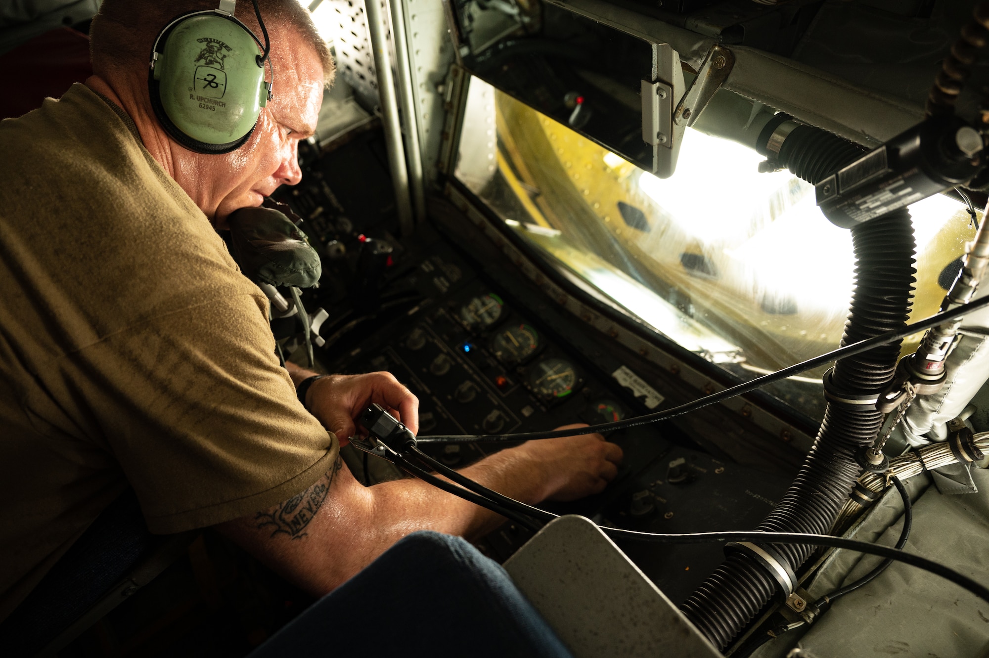 U.S. Air Force Col. Randy D. Schwinler, Commander 379th Expeditionary Maintenance Group, Al Udeid Air Base, Qatar, conducts a pre-flight check on a KC-135 Stratotanker, July 9, 2022. Schwinler checked the boom operations radio and control panel functionality while laying down in a pit located in the tail of the aircraft.  (U.S. Air Force photo by Staff Sgt. Dana Tourtellotte)