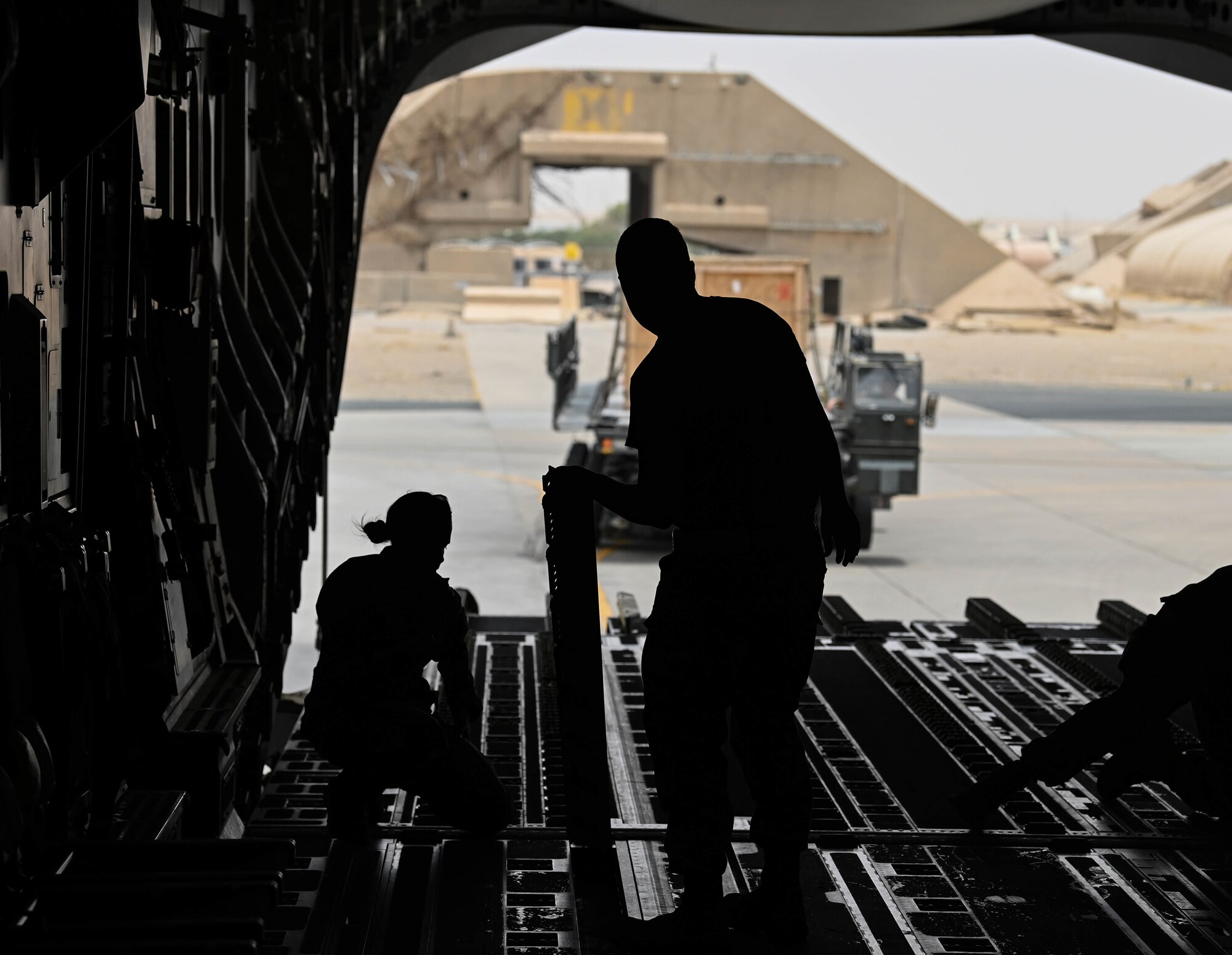 Airmen from the 386th Expeditionary Logistics Readiness Squadron prepare to load cargo onto a C-17 Globemaster aircraft assigned to Al Udeid Airbase Qatar, July 12, 2022 at Ali Al Salem Air Base, Kuwait. The 386th ELRS airmen worked with C-17 loadmasters to load cargo aboard the aircraft. (U.S. Air National Guard photo by Tech. Sgt. Michael J. Kelly)
