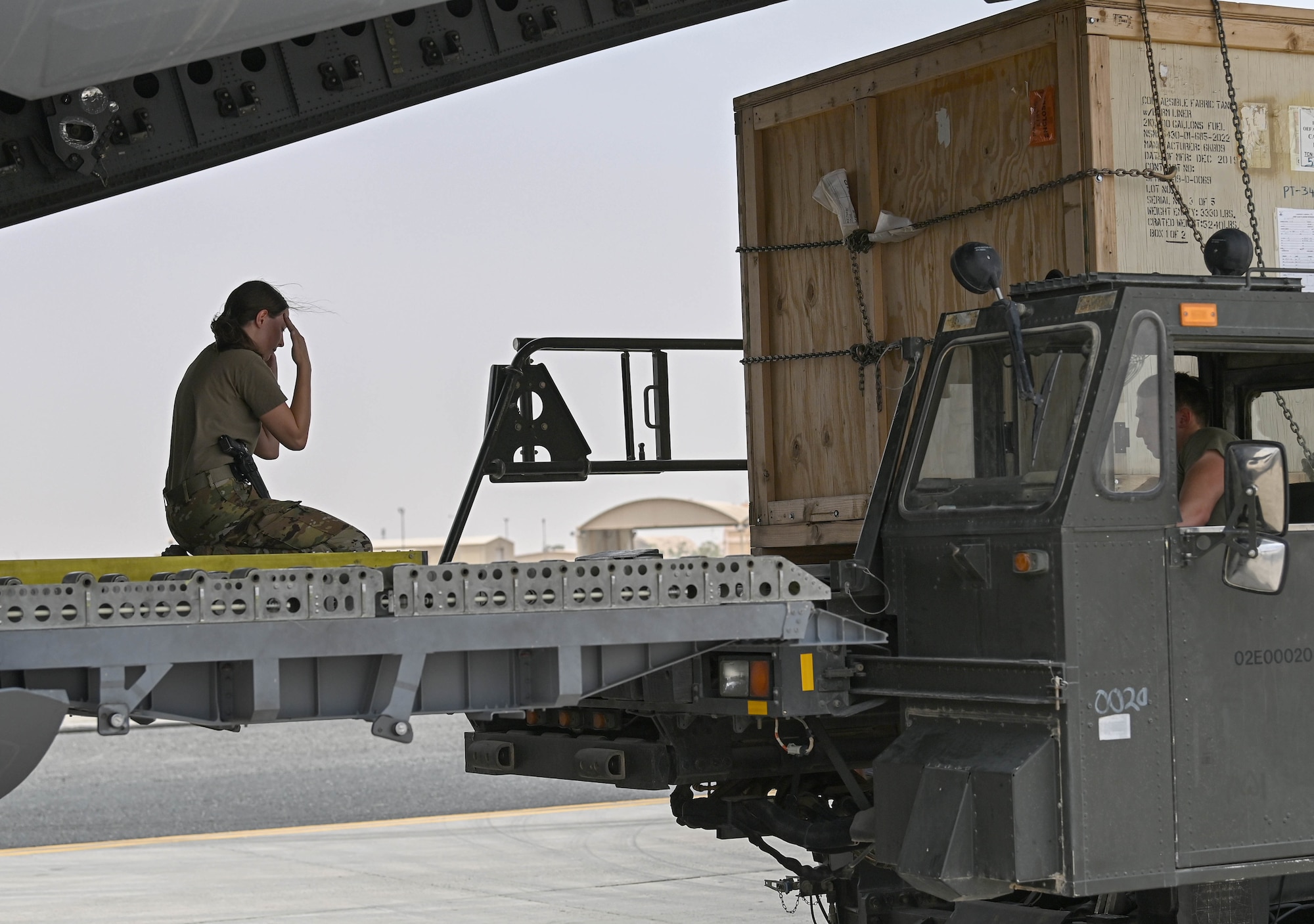 U.S. Air Force Senior Airman Nicole Snowden (left), an 816th Expeditionary Airlift Squadron loadmaster, directs the loading of cargo on a C-17 Globemaster aircraft July 12, 2022 at Ali Al Salem Air Base, Kuwait. The C-17, assigned to Al Udeid Airbase, Qatar, flies missions throughout the region transporting cargo and passengers. (U.S. Air National Guard photo by Tech. Sgt. Michael J. Kelly)
