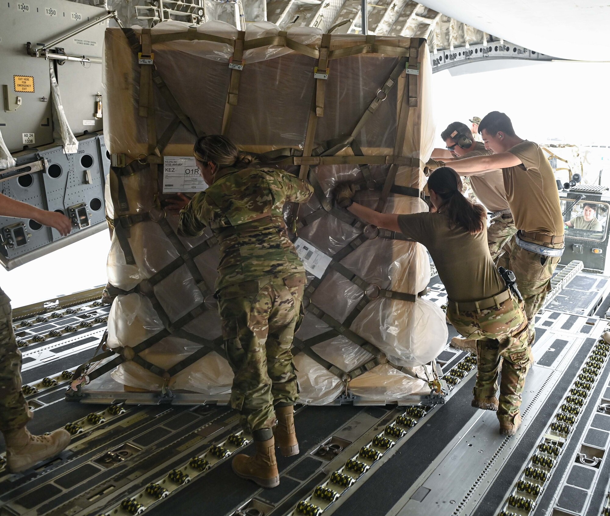 Airmen from the 386th Expeditionary Logistics Readiness Squadron along with l816th Expeditionary Airlift Squadron loadmasters position cargo aboard a C-17 Globemaster aircraft July 12, 2022 at Ali Al Salem Air Base, Kuwait. The C-17, assigned to Al Udeid Airbase, Qatar, transported the cargo to other bases in the region. (U.S. Air National Guard photo by Tech. Sgt. Michael J. Kelly)