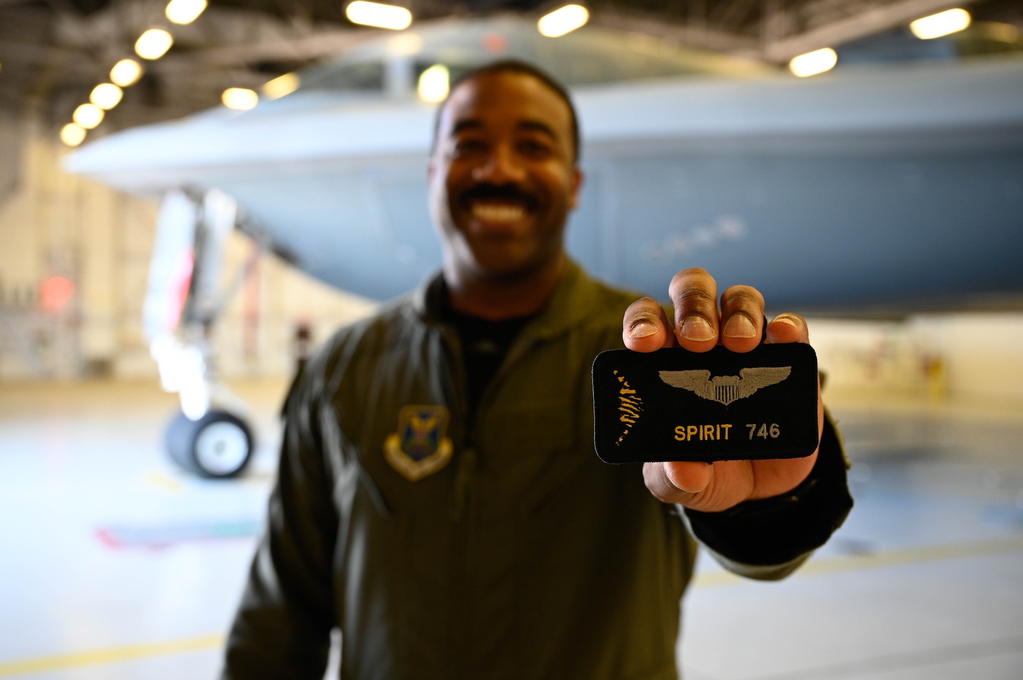 A U.S. Air Force B-2 Spirit pilot holds Spirit number patch for photo at Whiteman Air Force Base, Missouri, June 30, 2022. A Spirit number is a sequential number that is assigned only to a person who has flown in the B-2 Spirit Stealth Bomber. After completing their training, B-2 pilots take their first flight in the stealth bomber and receive their Spirit number. (U.S Air Force Photo by Senior Airman Christina Carter)