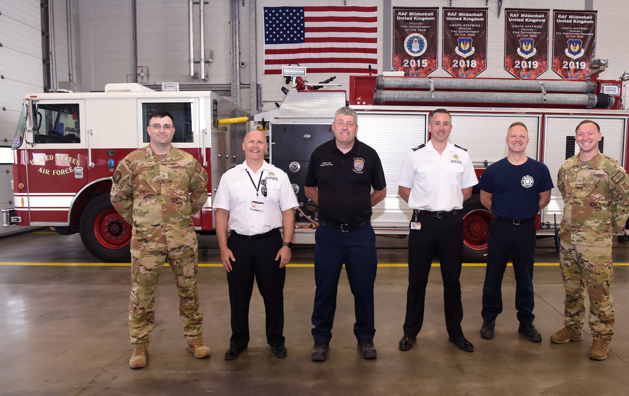 Henry Griffin, third from right, Suffolk Fire and Rescue area manager, and 100th Civil Engineer Squadron honorary commander, and Conrad Burgess, second left, Suffolk Fire and Rescue group training manager, visited the fire department to learn more about the assets that could be used for future mutual aid requests at Royal Air Force Mildenhall, England, July 13, 2022. They also spent time building relationships and discussed possible joint training between US and UK fire departments for the future. (U.S. Air Force photo by Karen Abeyasekere)