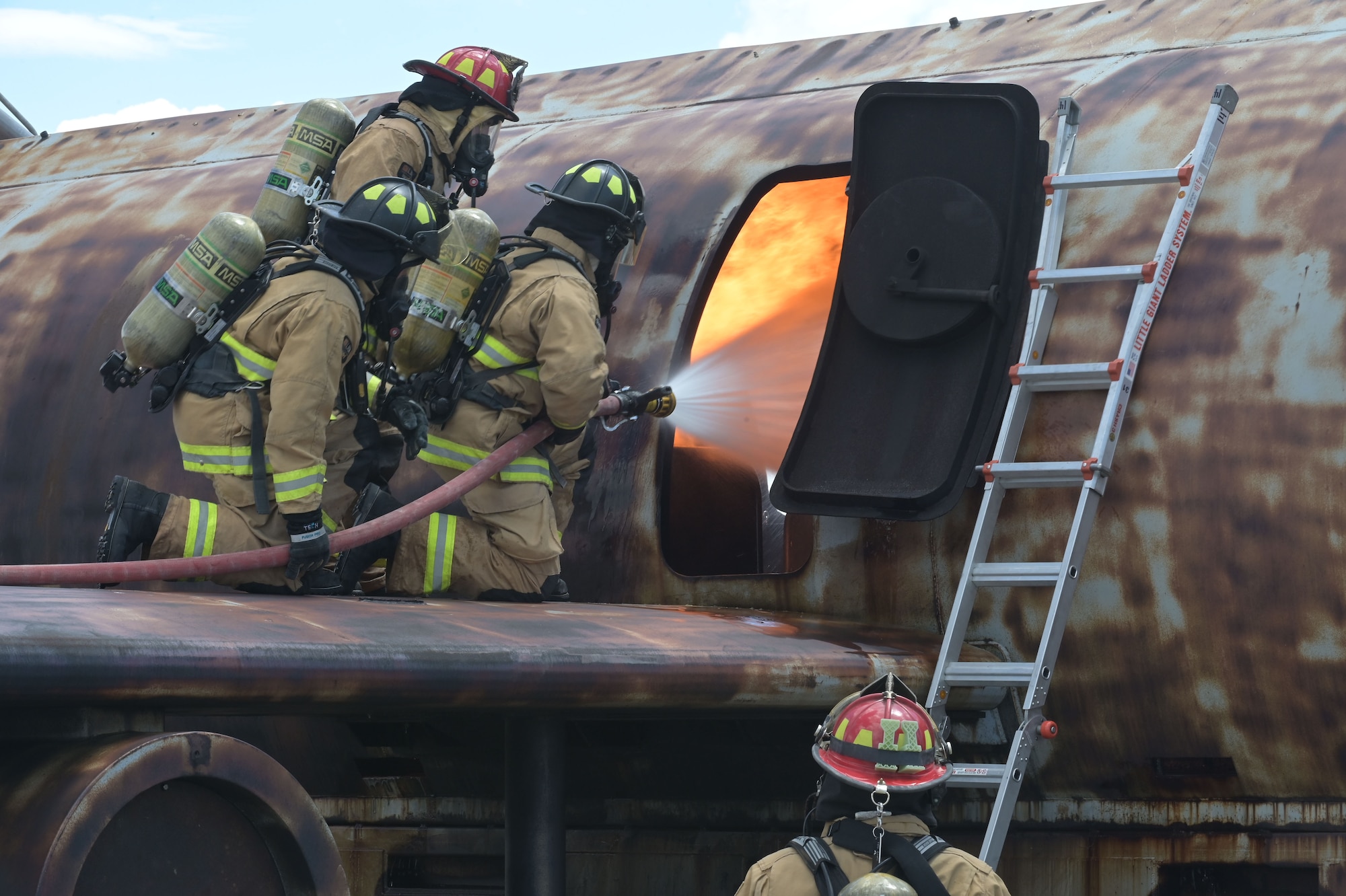 firefighters practice putting out fire on plane