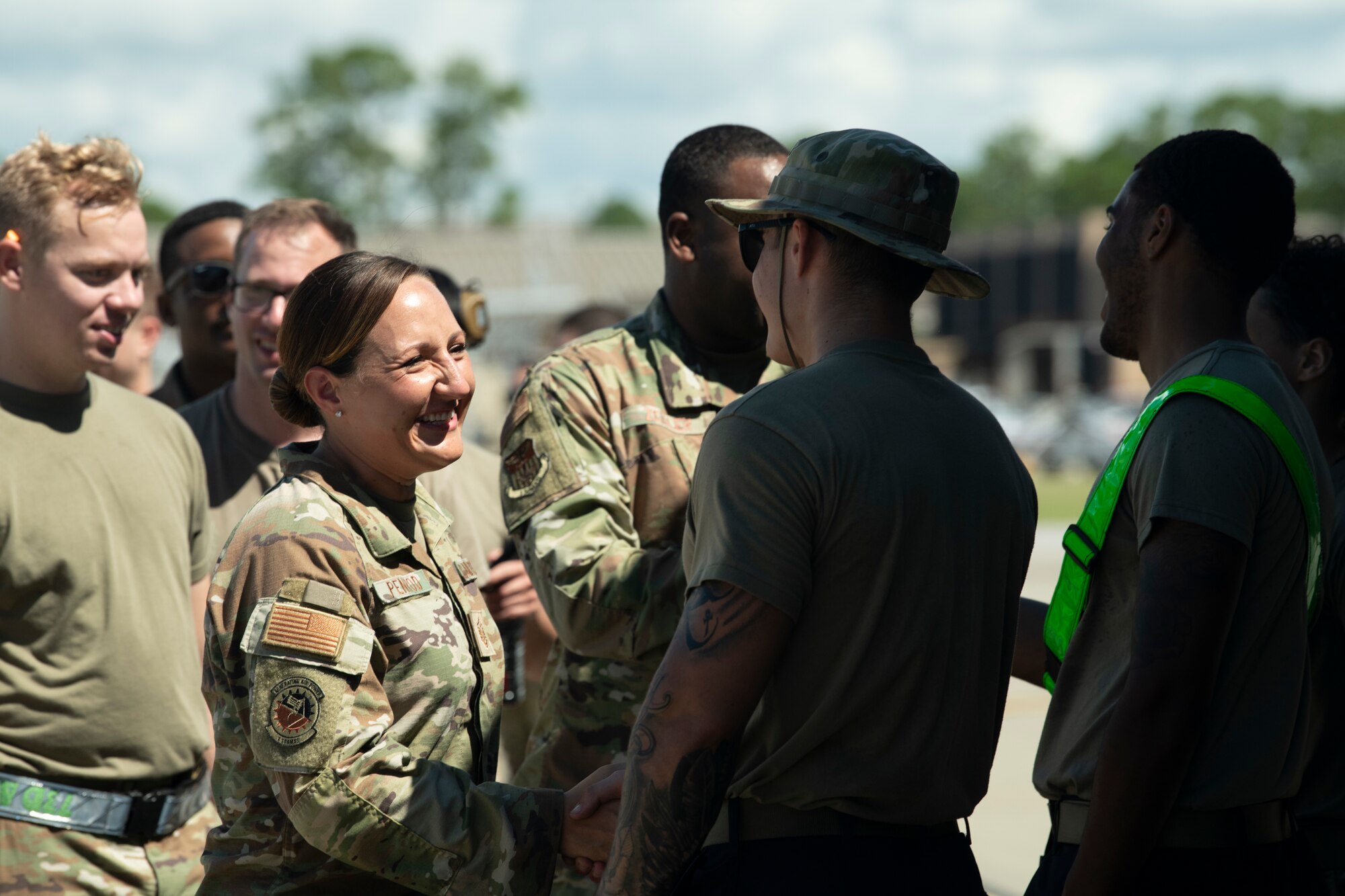 U.S. Air Force Master Sgt. Cheryl Penrod, the 1st Special Operations Maintenance Squadron First Sergeant (left), shakes hands with U.S. Air Force Senior Airman Caleb Beard, a 4th Aircraft Maintenance Unit weapons load crew member, at Hurlburt Field, Florida, July 8, 2022.