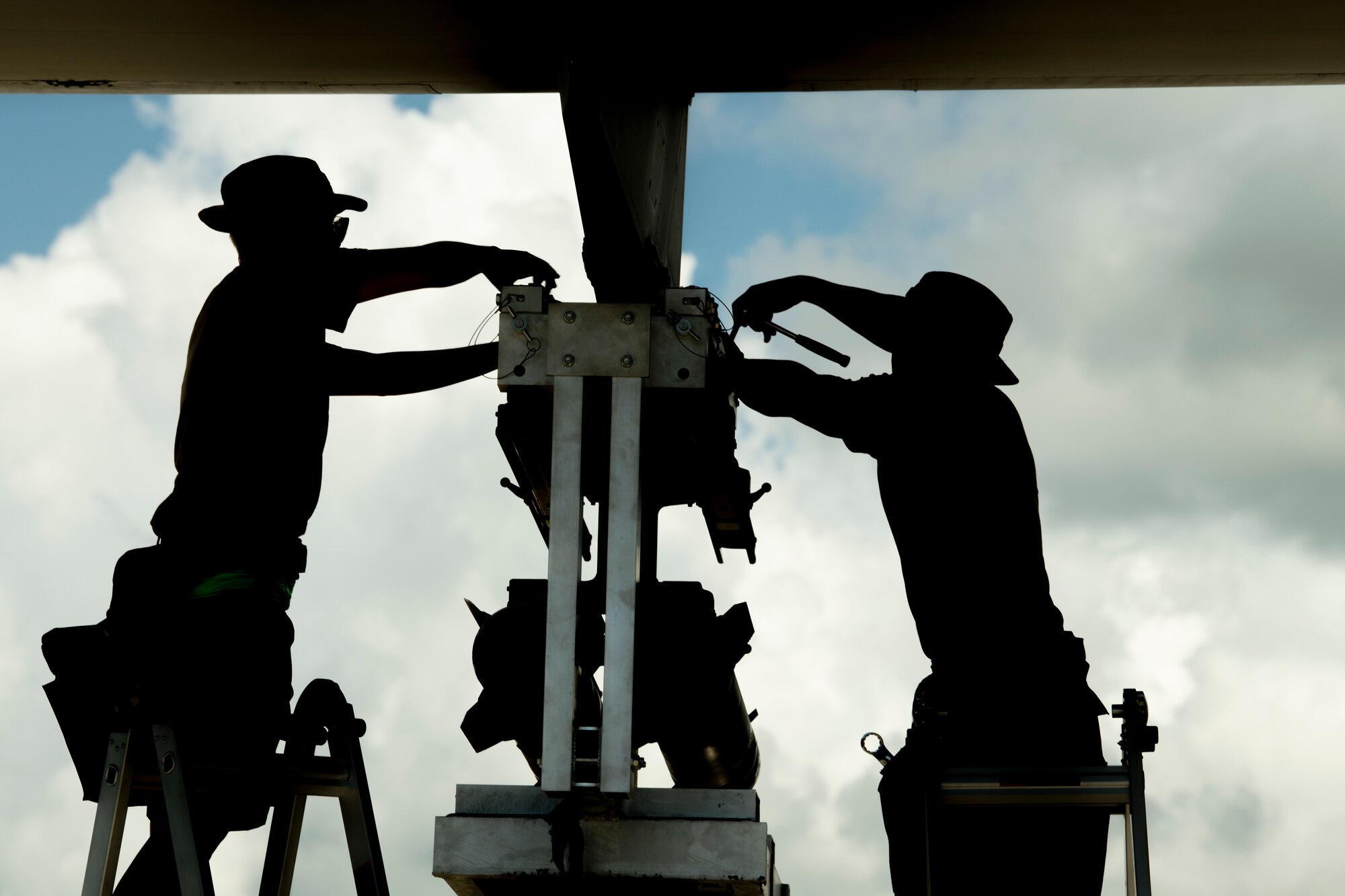 U.S. Air Force Senior Airman Shaylyn Stinson, a 4th Aircraft Maintenance Unit weapons load crew chief (left), and U.S. Air Force Senior Airman Caleb Beard, a 4th AMU weapons load crew member, secure AGM-114 Hellfire missiles to an AC-130 Whiskey training aircraft simulating an AC-130J Ghostrider during a quarterly load crew competition at Hurlburt Field, Florida, July 8, 2022.