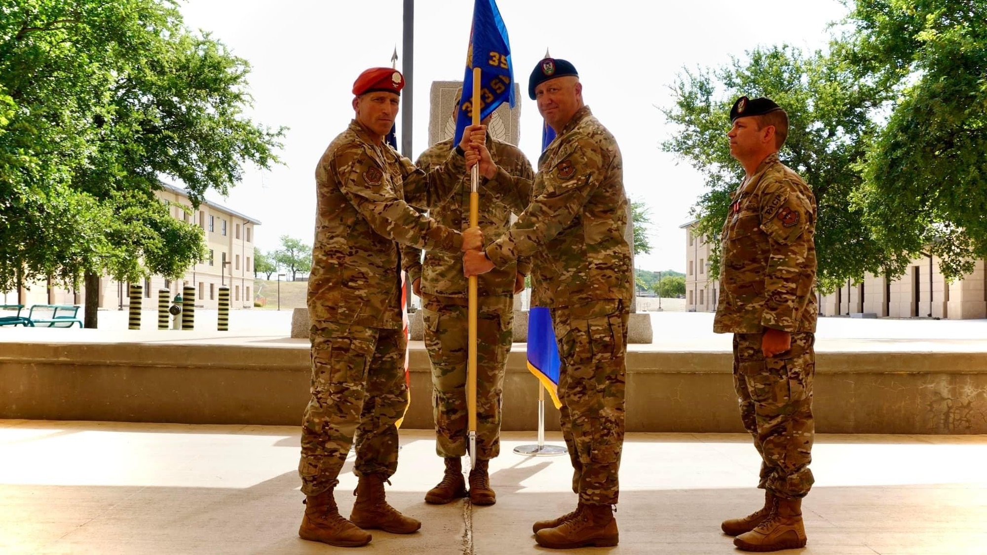 U.S. Air Force Col. Mason Dula (left), Special Warfare Training Wing commander and presiding officer, passes the guidon to Lt. Col. Christopher Deaver, incoming 353rd Special Warfare Training Squadron commander, during the 353rd SWTS change of command ceremony at Joint Base San Antonio-Chapman Training Annex, Texas, June 3, 2022. At right is Lt. Col. Matthew McMurtry, outgoing 353rd SWTS commander.