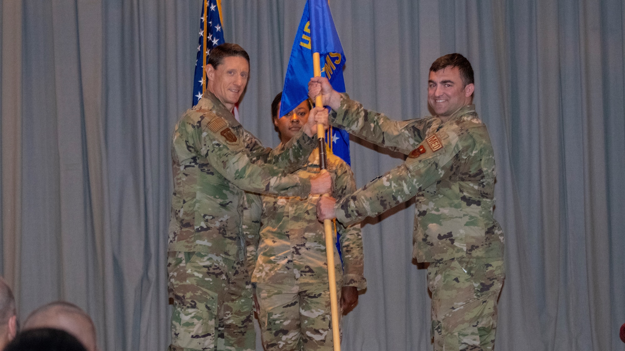 U.S. Air Force Col. George Buse (left), Special Warfare Human Performance Support Group commander and presiding officer, passes the guidon to Lt. Col. Gary D'Orazio (right), incoming Special Warfare Operational Medicine Squadron commander, during the SWOMS change of command ceremony at Joint Base San Antonio-Chapman Training Annex, Texas, July 15, 2022.