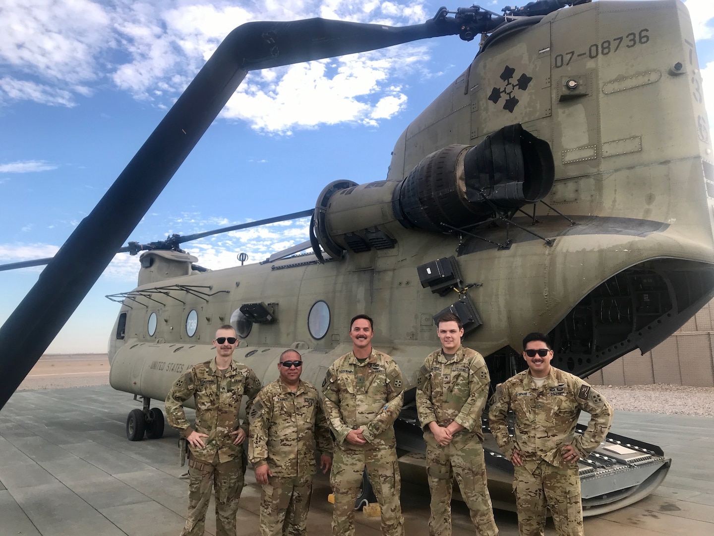 Five Washington National Guard crew members pose in front of their CH-47 Chinook helicopter, damaged in Afghanistan Nov. 20, 2020. All five were awarded the U.S. Army Aviation Broken Wing Award  in a ceremony at the Army Aviation Support Facility #1 at Joint Base Lewis-McChord June 18, 2022.