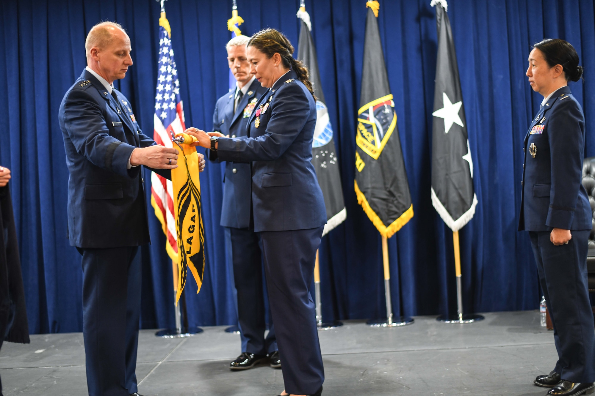 Col Becky Beers, previous commander, Los Angeles Garrison, right, retires the Los Angeles Garrison guidon with Lt. Gen. Michael Guetlein, commander, Space Systems Command, left, on July 14 at Los Angeles Air Force Base. Chief Master Sgt. Michael Groder, acting Senior Enlisted Leader for SBD 3, assists with the guidon.