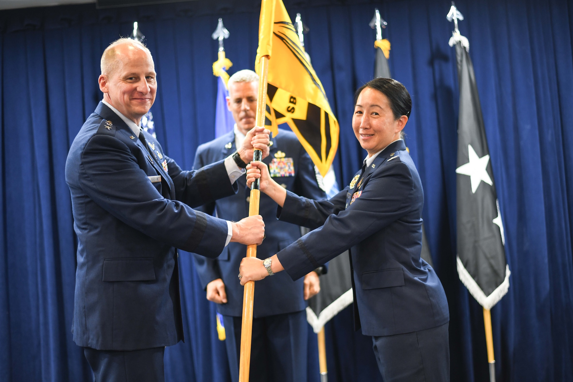 Col. Mia Walsh, commander, Space Base Delta 3, right, assumes command of SBD 3 from Lt. Gen. Michael Guetlein, commander, Space Systems Command, left, on July 14 at Los Angeles Air Force Base.  Chief Master Sgt. Michael Groder, acting Senior Enlisted Leader for SBD 3, assists with the change of command.
