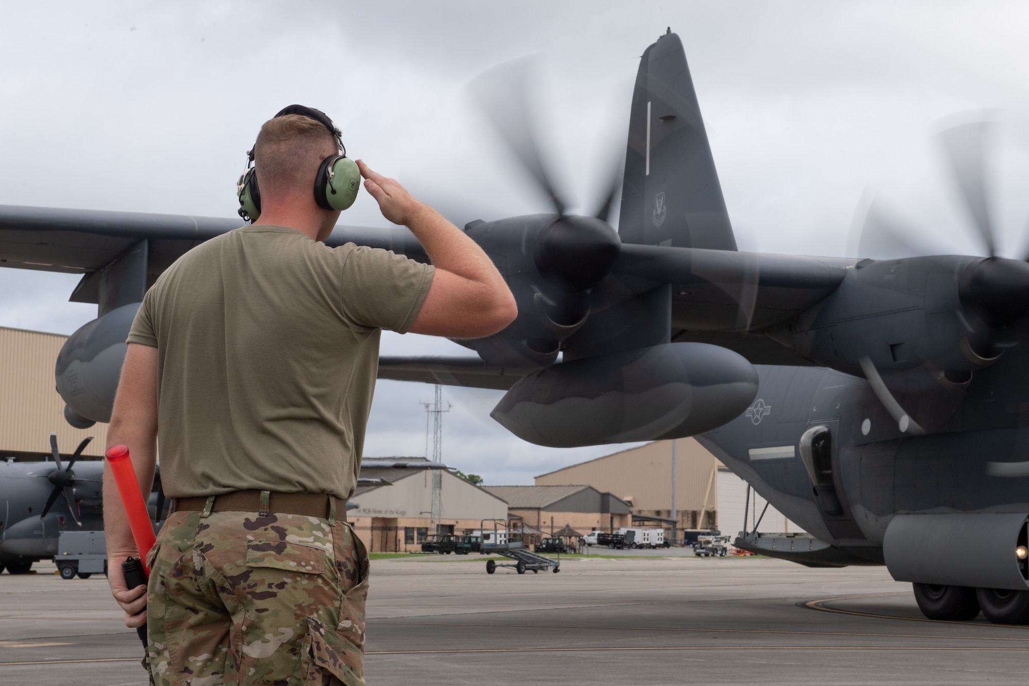 U.S. Air Force Senior Airman Clark Ivey, 71st Rescue Generation Squadron assistant dedicated crew chief, sends off an HC-130J Combat King II for its Black Letter flight on July 12, 2022, at Moody Air Force Base, Georgia. In honor of his achieving a rare, defect-free Black letter flight, Ivey marshalled the aircraft out and rendered the customary salute. (U.S. Air Force photo by Staff Sgt. John Crampton)