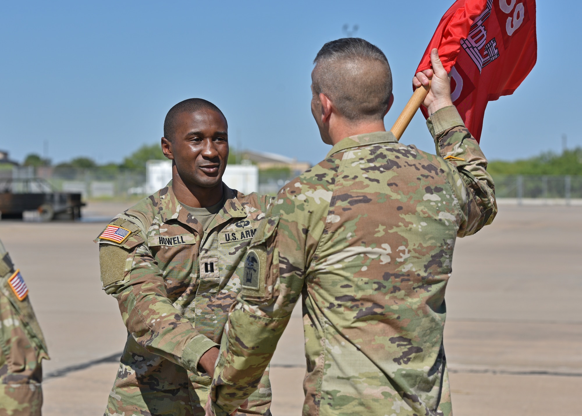U.S. Army Capt. Jarred Howell, left, incoming Delta Company 169th Engineer Battalion commander, passes the guidon to 1st Sgt. Elisha Conway, D CO 169th EN BN first sergeant, during their change of command at Goodfellow Air Force Base, Texas, July 15, 2022. Howell was previously the commander of Bravo Company 169th EN BN. (U.S. Air Force photo by Senior Airman Ashley Thrash)