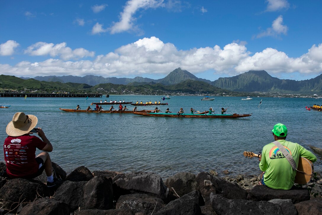 Spectators encourage teams during the John D. Kaupiko Regatta race Kaneohe Bay, July 14, 2019. The event was open to the military, civilians and surrounding community to help foster sportsmanship and esprit de corps. (U.S. Marine Corps photo by Pfc. Jose Angeles)
