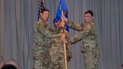U.S. Air Force Col. George Buse (left), Special Warfare Human Performance Support Group commander and presiding officer, passes the guidon to Lt. Col. Gary D'Orazio (right), incoming Special Warfare Operational Medicine Squadron commander, during the SWOMS change of command ceremony at Joint Base San Antonio-Chapman Training Annex, Texas, July 15, 2022.