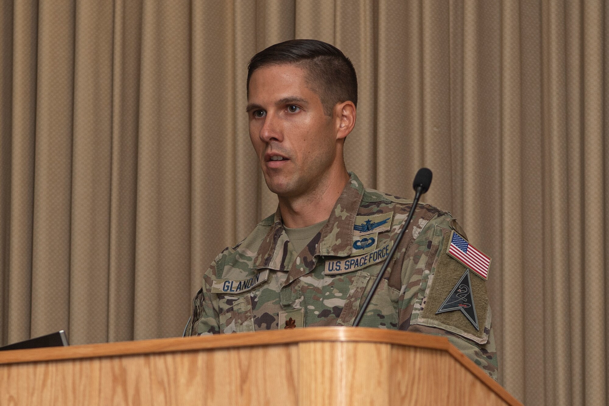 Man in military uniform speaking at podium