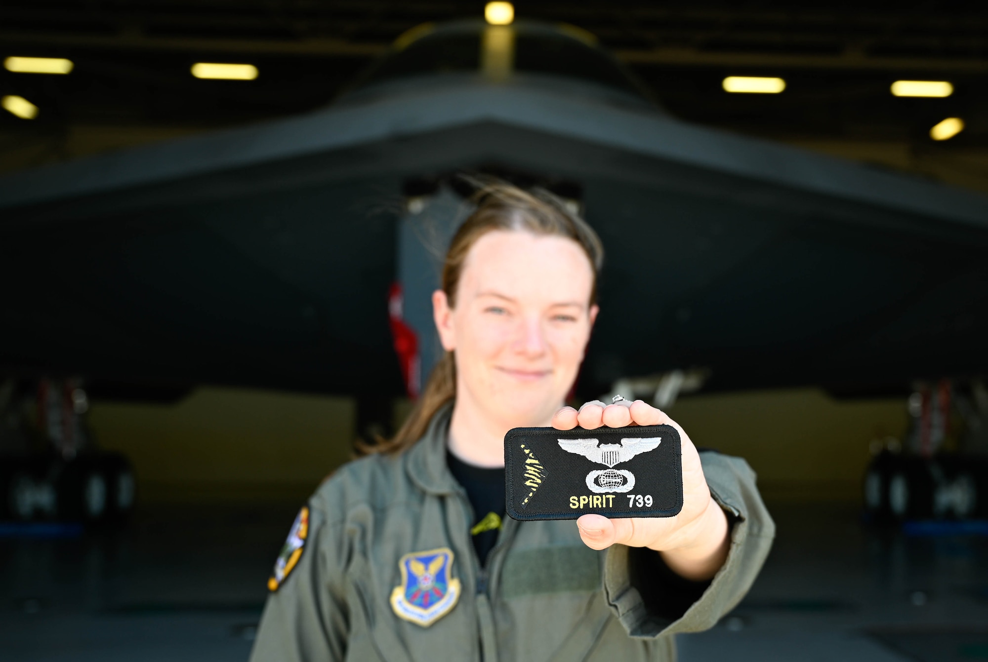 A U.S. Air Force B-2 Spirit pilot holds Spirit number patch for photo at Whiteman Air Force Base, Missouri, June 30, 2022. A Spirit number is a sequential number that is assigned only to a person who has flown in the B-2 Spirit Stealth Bomber. After completing their training, B-2 pilots take their first flight in the stealth bomber and receive their Spirit number. (U.S Air Force Photo by Senior Airman Christina Carter)