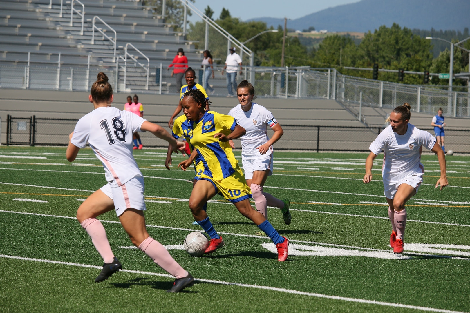 Mali's #10 Binta Diarra drives through French defenders during match 11 of the 13th Conseil International du Sport Militaire (CISM) World Women's Military Football Championship hosted by Fairchild Air Force Base in Spokane, Washingon.  This year's championship features teams from the United States, Belgium, Cameroon, Canada, France, Germany, Ireland, Mali, Netherlands, and South Korea.  (Department of Defense Photo by Mr. Steven Dinote, released).