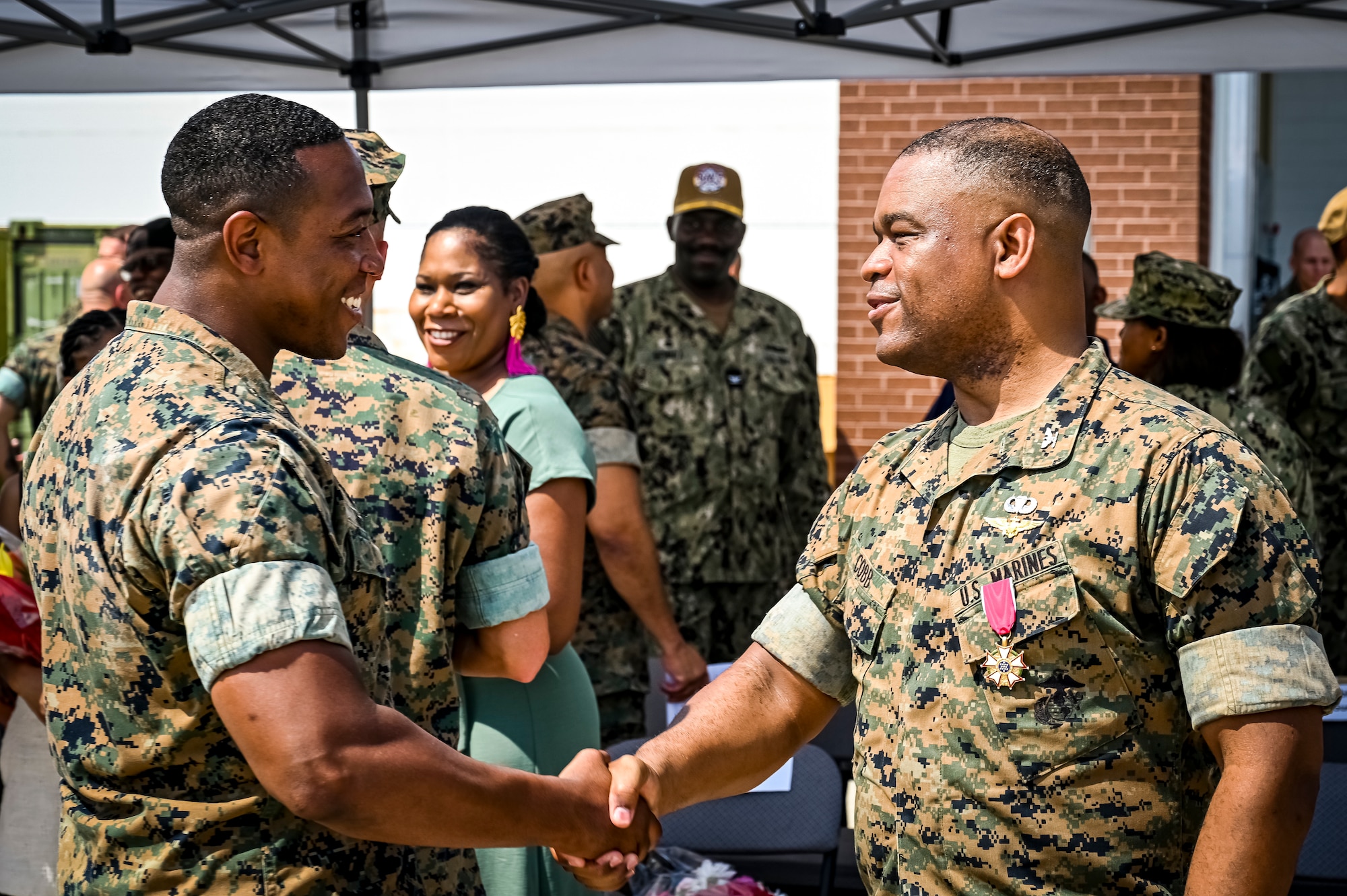 A U.S. Marine assigned to Marine Aircraft Group 49 shakes the hand of U.S. Marine Corps. Col. Lonnie Cobb following a change of command ceremony on July 16, 2022 at Joint Base McGuire Dix Lakehurst. The change of command ceremony is a military tradition that represents a formal transfer of authority and responsibility for a unit from one officer to another. The mission of MAG 49 is to organize, train, and equip combat ready squadrons to augment and reinforce the active Marine forces in time of war, national emergency, or contingency operations, and to provide personnel and assault support capabilities to relieve operational tempo for active duty forces. (U.S. Air Force Photo by Senior Airman Matt Porter)