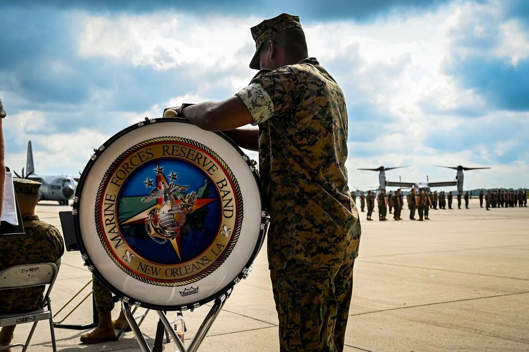 U.S. Marines assigned to Marine Aircraft Group 49 play instruments as part of a band in preparation for a change of command ceremony on July 16, 2022 at Joint Base McGuire Dix Lakehurst. The change of command ceremony is a military tradition that represents a formal transfer of authority and responsibility for a unit from one officer to another. The mission of MAG 49 is to organize, train, and equip combat ready squadrons to augment and reinforce the active Marine forces in time of war, national emergency, or contingency operations, and to provide personnel and assault support capabilities to relieve operational tempo for active duty forces. (U.S. Air Force Photo by Senior Airman Matt Porter)