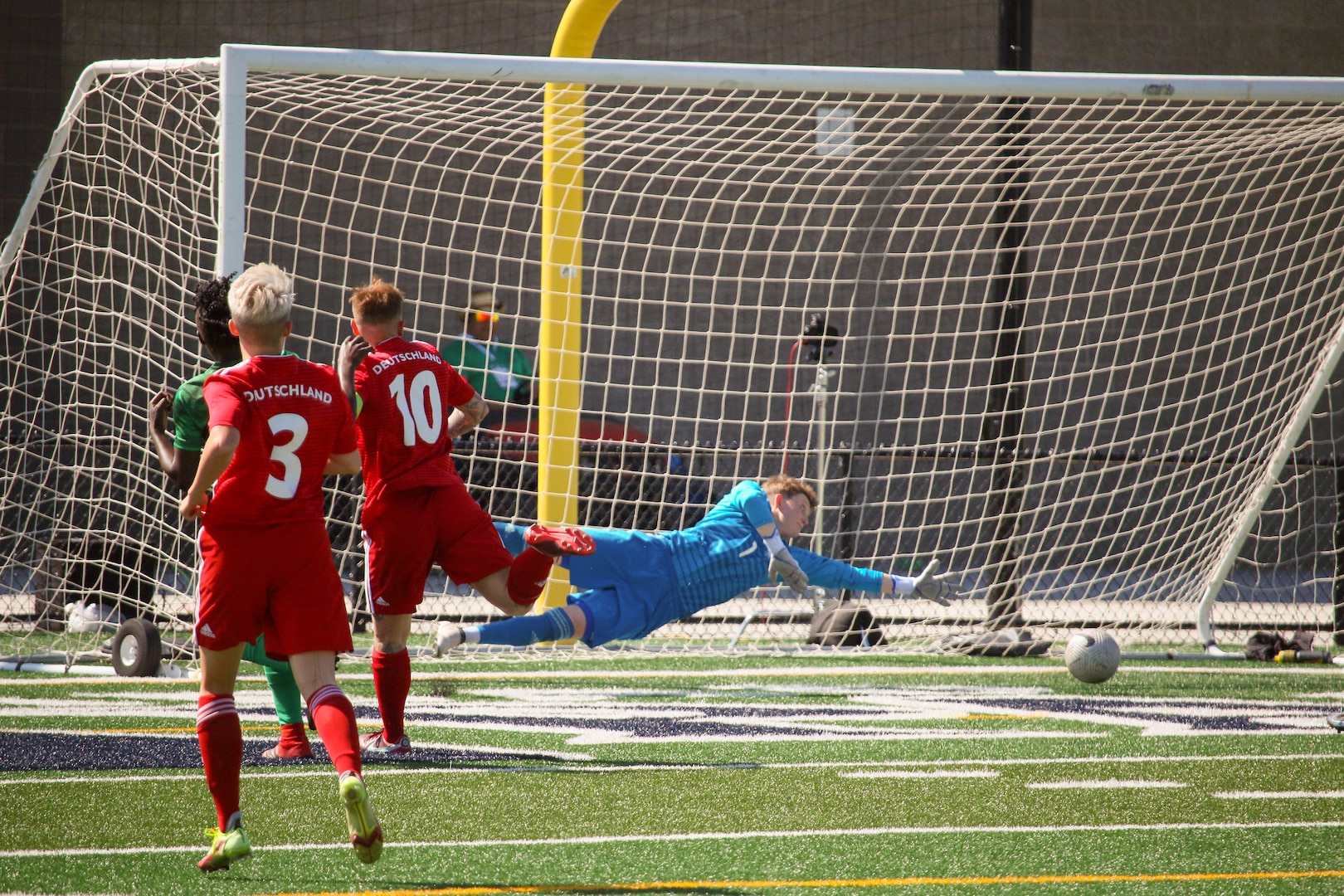 Cameroon's Ebika Tabe scores past the diving German goalkeeper, Gina-Marie Mitschke in match 13 of the 13th Conseil International du Sport Militaire (CISM) World Women's Military Football Championship hosted by Fairchild Air Force Base in Spokane, Washingon.  This year's championship features teams from the United States, Belgium, Cameroon, Canada, France, Germany, Ireland, Mali, Netherlands, and South Korea.  (Department of Defense Photo by Mr. Steven Dinote, released).