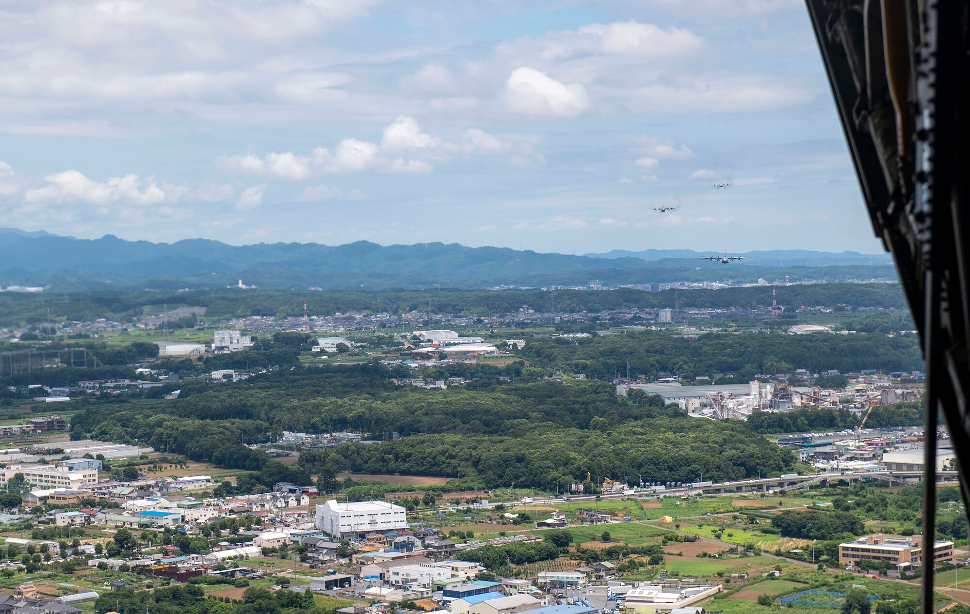 A C-130J Super Hercules and two C-130H Hercules fly over Japan