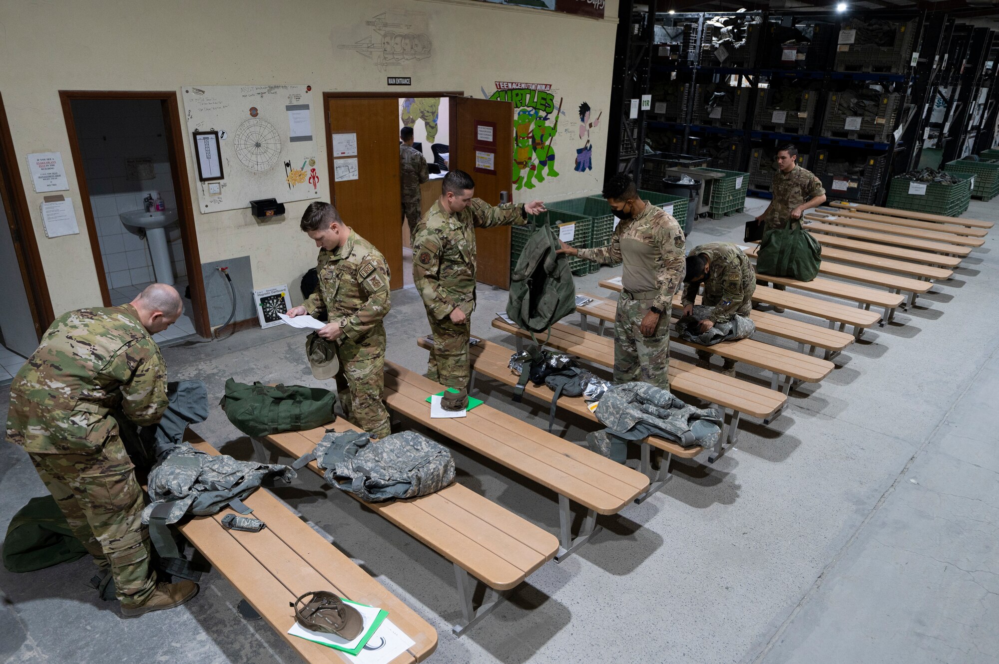 Airmen from the 386th Expeditionary Civil Engineer Squadron turn in their helmets, tactical vests, armored plates and other equipment at the Expeditionary Theater Distribution Center, Ali Al Salem Air Base, Kuwait, July 13, 2022. Approximately 400 military personnel process through the ETDC each week. (U.S. Air Force photo by Staff Sgt. Dalton Williams)
