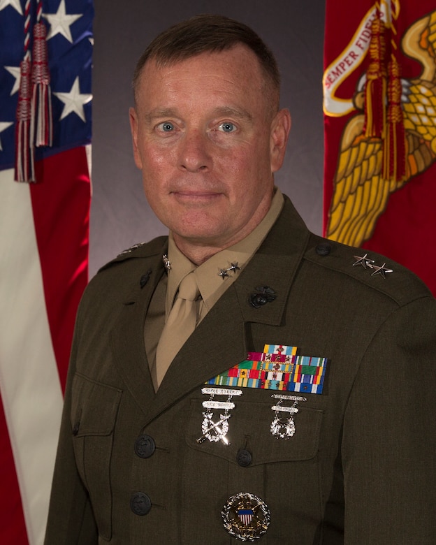 A headshot of Major General David W. Maxwell in front of the American flag and the Marine Corps flag.