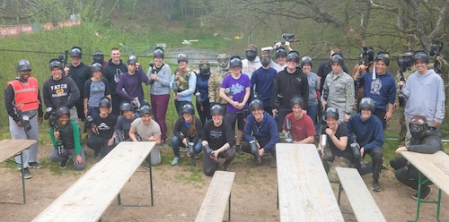 Authentic Happiness attendees pose for photo after paintball