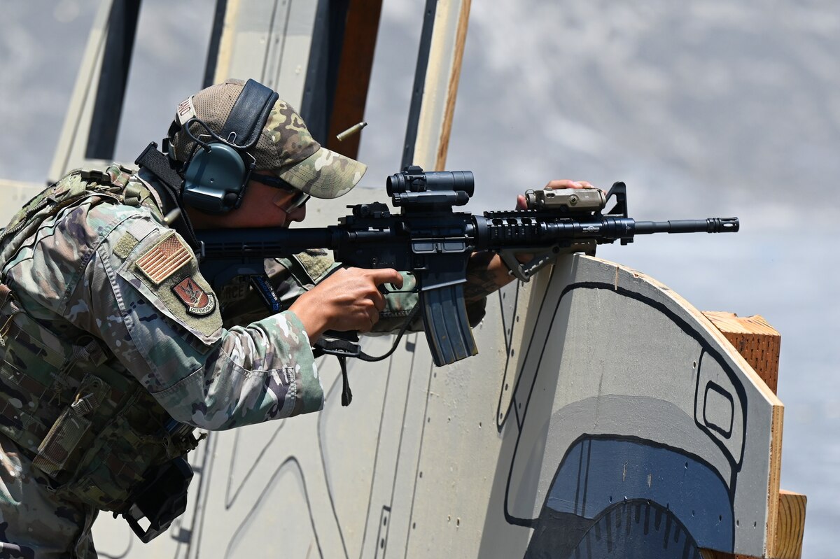 U.S Air Force Staff Sergeant Fernando Manzano, defender with the 162nd Security Forces Squadron, fires an M4 carbine from cover at a firing range at Kirtland AFB, July 10, 2022. The 161st conducted their annual training alongside the 162nd Security Forces Squadron to share ideas, tactics and techniques, equipment uses. (U.S. Air National Guard photo by Staff Sgt. Jayson Burns)