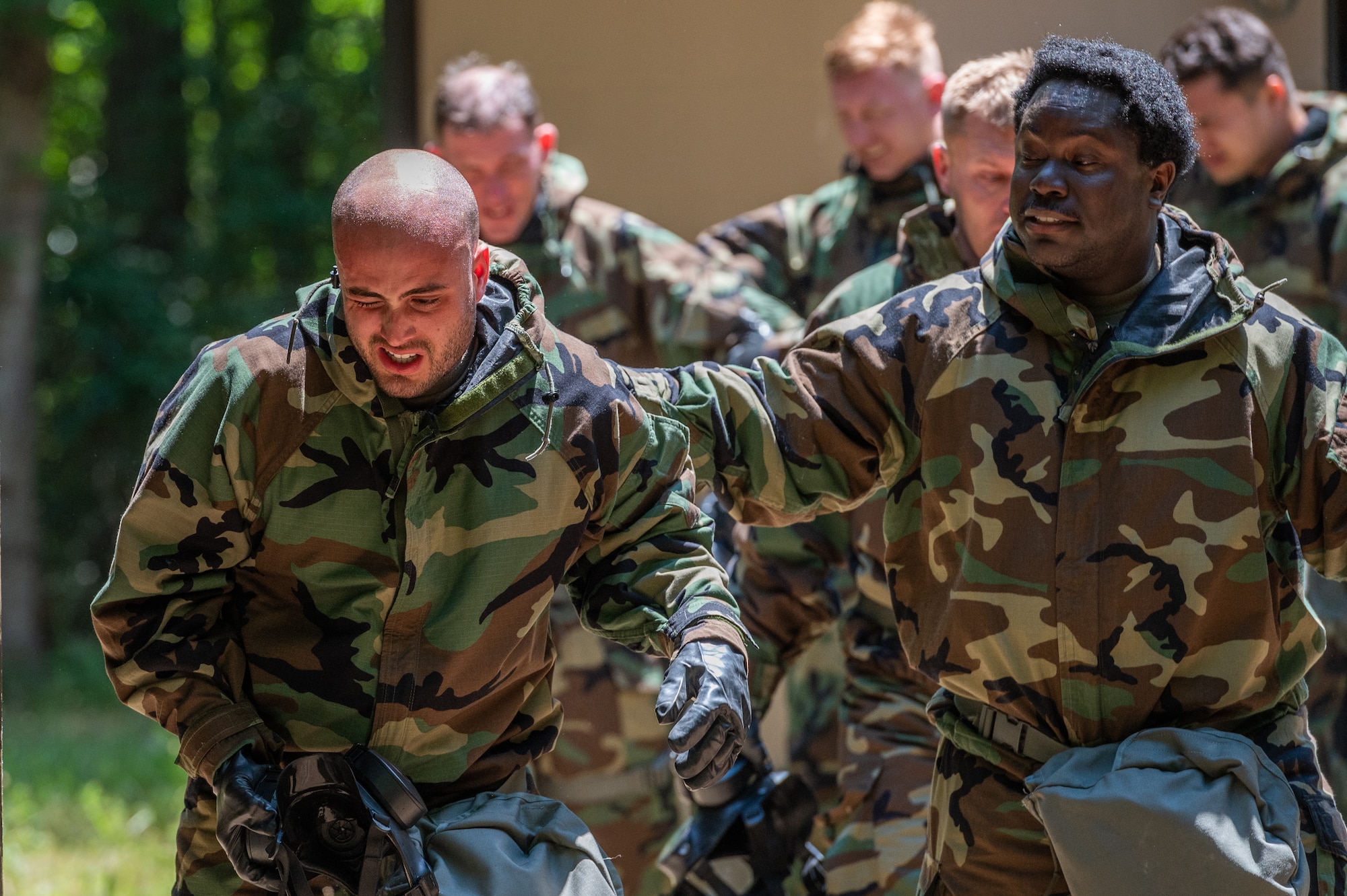 U.S. Air Force Airmen assigned to the 87th Civil Engineering Group emerge after being exposed to CS gas during an Ability to Survive and Operate exercise at Joint Base McGuire-Dix-Lakehurst, N.J., July 14, 2022. The exercise provided Airmen with in-depth instruction on basic survival and operational skills in a contested environment. (U.S. Air Force photo by Airman 1st Class Sergio Avalos)