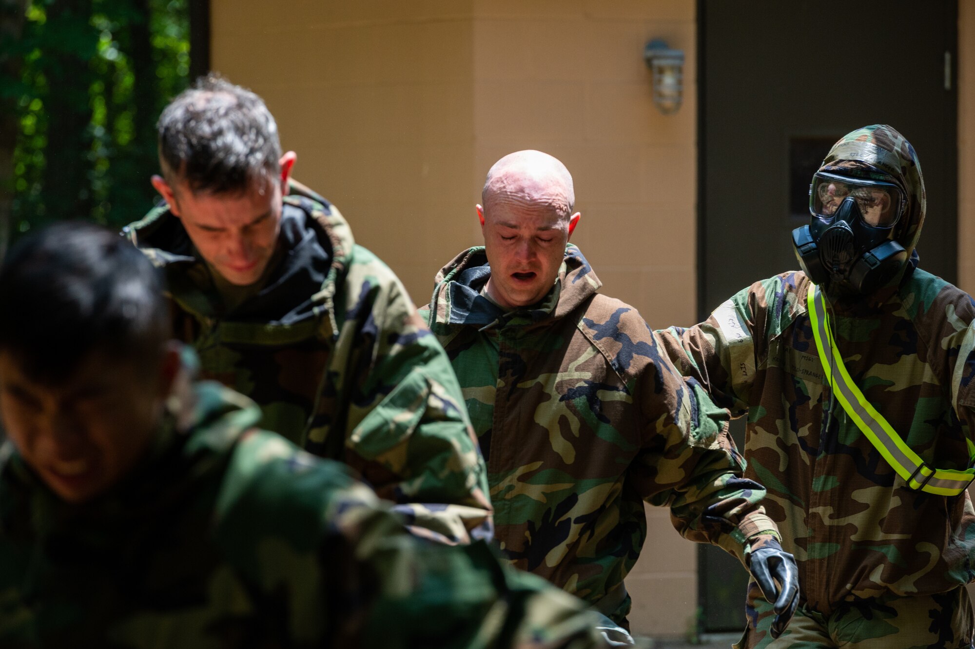 U.S. Air Force Airmen assigned to the 87th Civil Engineering Group emerge after being exposed to CS gas during an Ability to Survive and Operate exercise at Joint Base McGuire-Dix-Lakehurst, N.J., July 14, 2022. The exercise provided Airmen with in-depth instruction on basic survival and operational skills in a contested environment. (U.S. Air Force photo by Airman 1st Class Sergio Avalos)