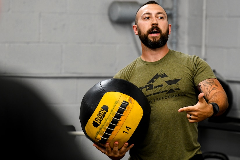 A man works out with a heavy ball.