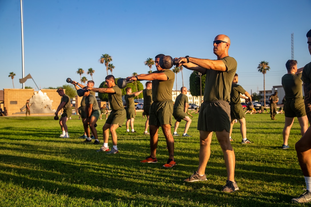 U.S. Marines with Headquarters and Headquarters Squadron conduct kettlebell swings during a squadron physical training event at Marine Corps Air Station Yuma, Arizona, June 29, 2022. The event was former commanding officer Lt. Col. Robert Reinoehl’s final physical fitness event with the unit prior to his change of command ceremony, June 30, 2022. (U.S. Marine Corps photo by Cpl. Gabrielle Sanders)