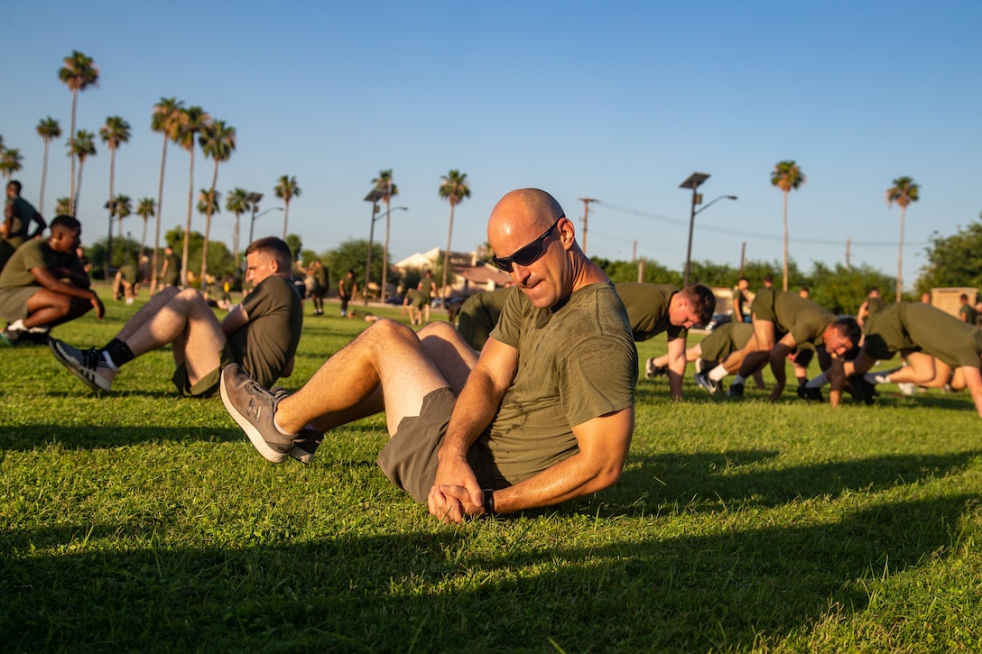 U.S. Marine Corps Lt. Col. Robert Reinoehl, commanding officer, Headquarters and Headquarters Squadron, performs an exercise during a squadron physical training event at Marine Corps Air Station Yuma, Arizona, June 29, 2022.