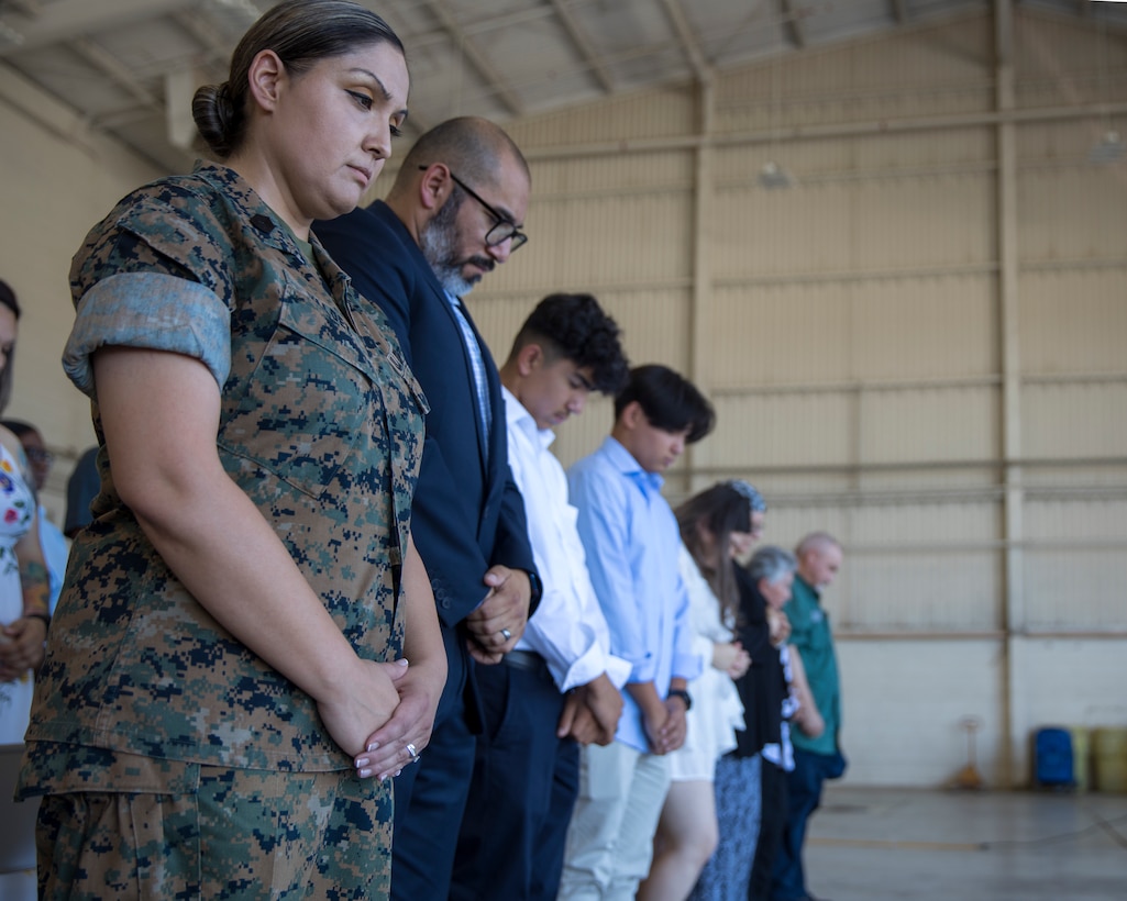 U.S. Marine Corps Master Sgt. Maribel Valdez, administrative chief, Marine Aviation Logistics Squadron 13 (MALS-13), 3rd Marine Aircraft Wing, prays with her family during her retirement ceremony at Marine Corps Air Station Yuma, Arizona, June 24, 2022.