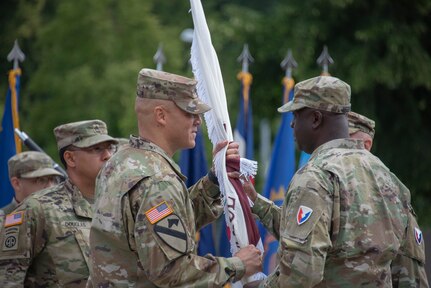 Army Medical Logistics Command Commander Col. Tony Nesbitt (right) passes the organizational colors to Col. Deon Maxwell (left) as he assumes command of the U.S. Army Medical Materiel Center - Europe, a direct reporting unit of AMLC. (Katie Ellis-Warfield)